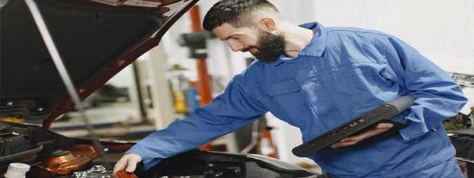 Mechanic checking a car with bonnet open