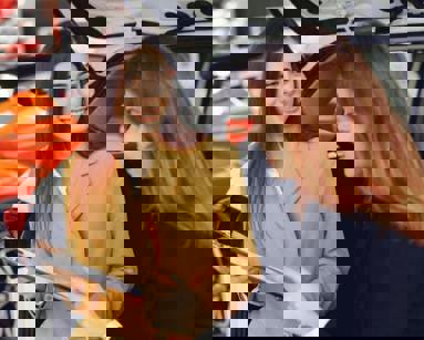 young woman and car dealer discussing paperwork