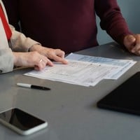 two people reviewing documents at a table
