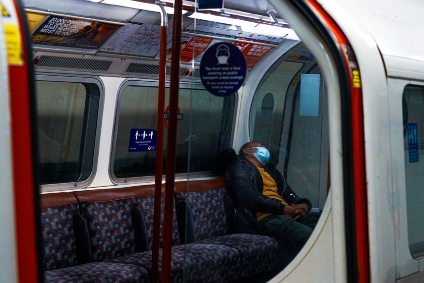 man in black jacket sitting on a train seat