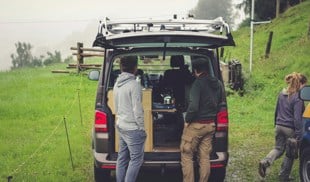 people standing at the back on an open vehicle