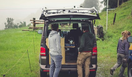 people standing at the back on an open vehicle