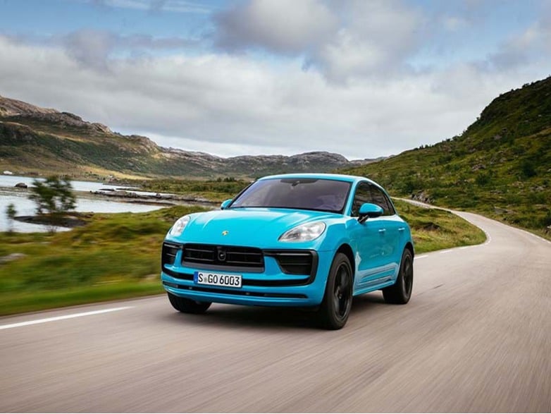 blue porsche macan driving on road