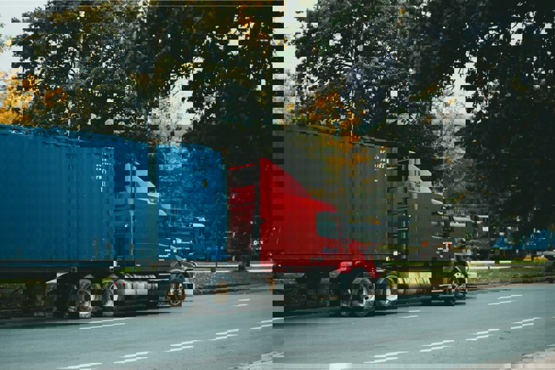 a red semi truck driving down a street