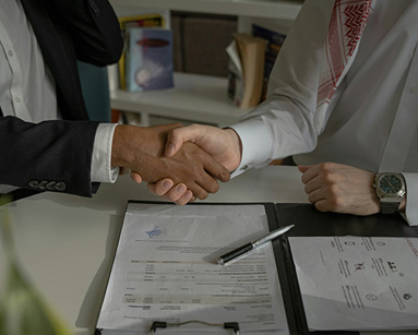men shaking hands over a piece of paper