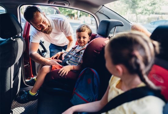 Father caring his kids to be safe during road trip