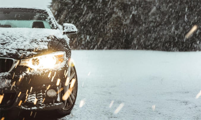 black car on snow covered road during daytime
