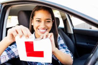 Young female driver ripping her learner driving L plates up