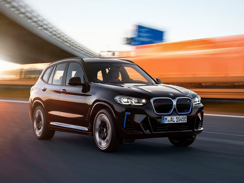 black bmw ix3 driving on the road