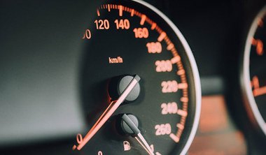 A close up of a car speedometer. 