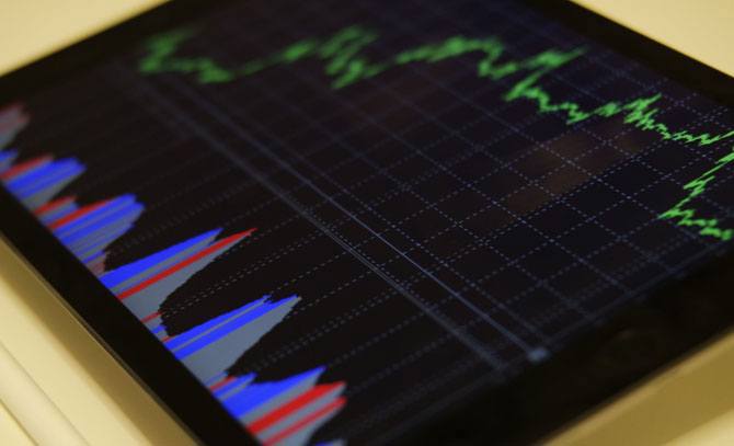 Close up of a tablet device showing stocks and shares graph. 
