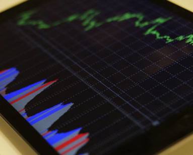 Close up of a tablet device showing stocks and shares graph. 