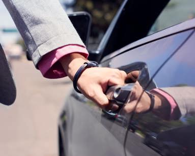 Person opening car door with hand on the door handle