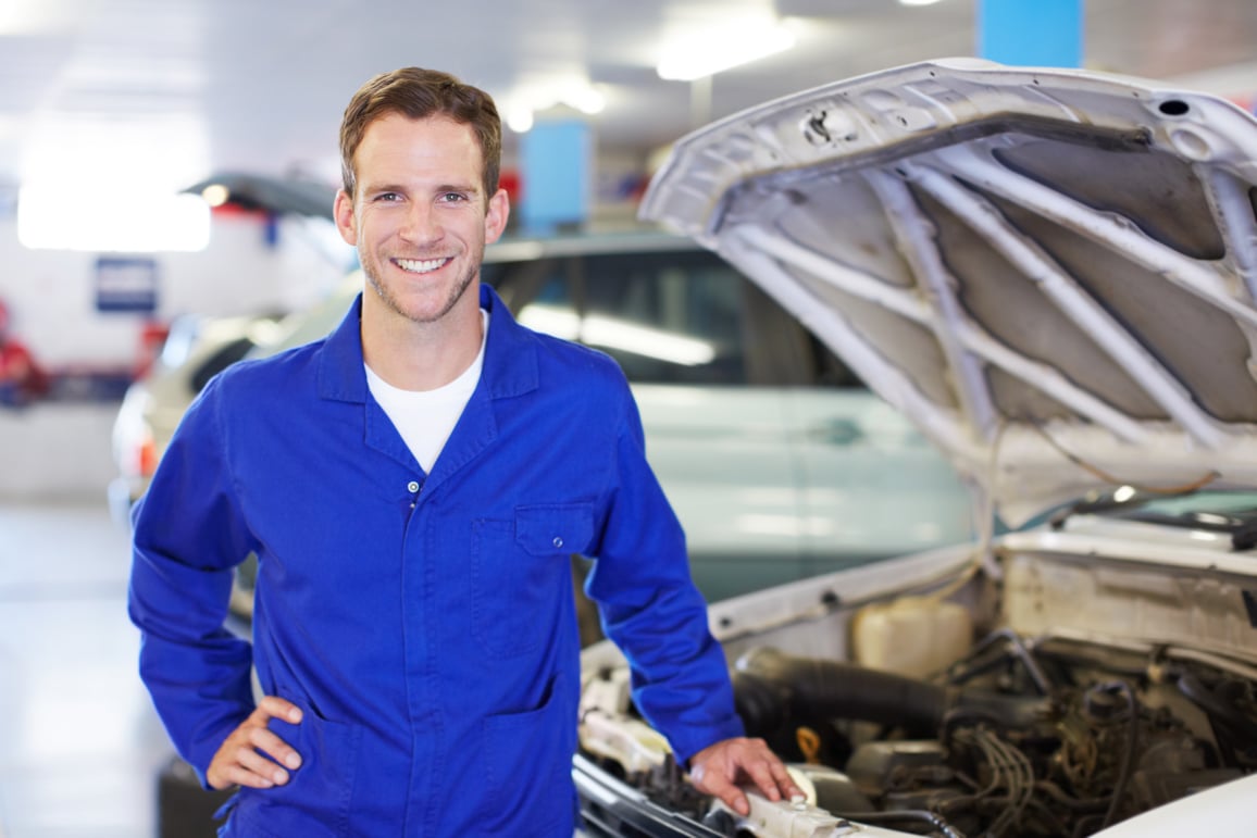 mechanic standing next to a van with its bonnet open