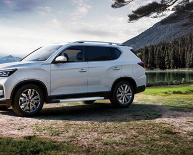 White KGM Rexton in front of a lake