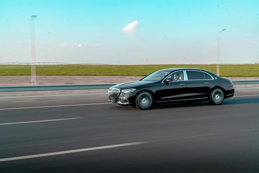 Black saloon car driving on a modern road