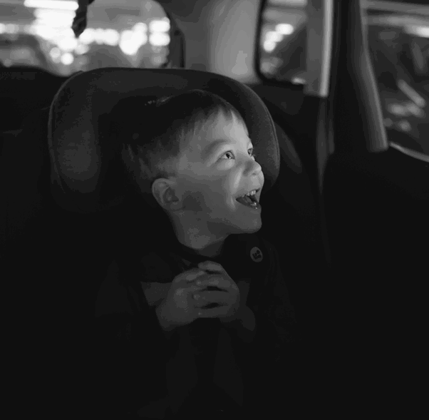 a little boy sitting in a car seat