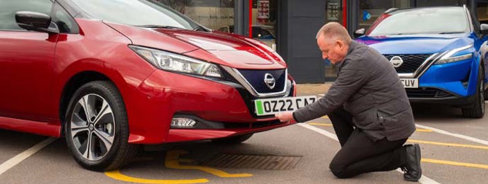 dealer putting registration plate onto car