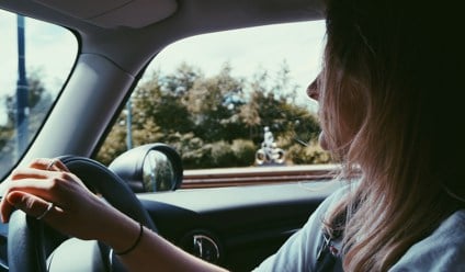 woman holding steering wheel in car