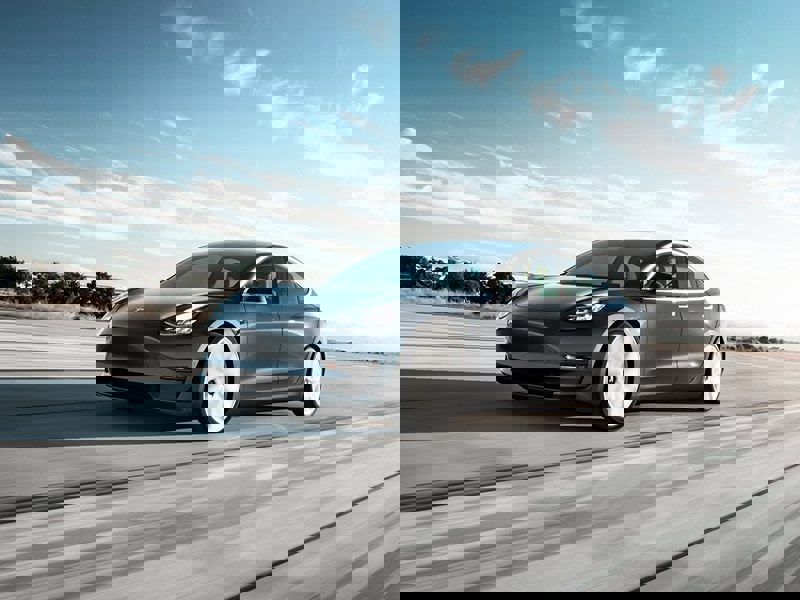 grey tesla model 3 driving fast
