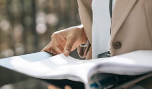 Person holding a binder full of documents