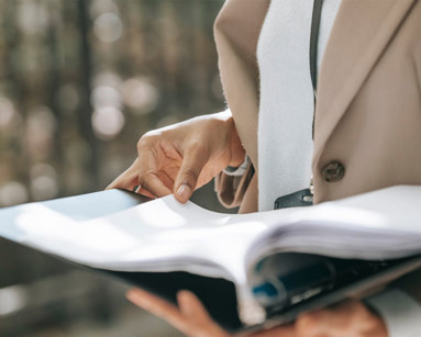 Person holding a binder full of documents
