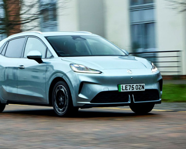 MG4 EV Urban driving on a road with modern housing in the background