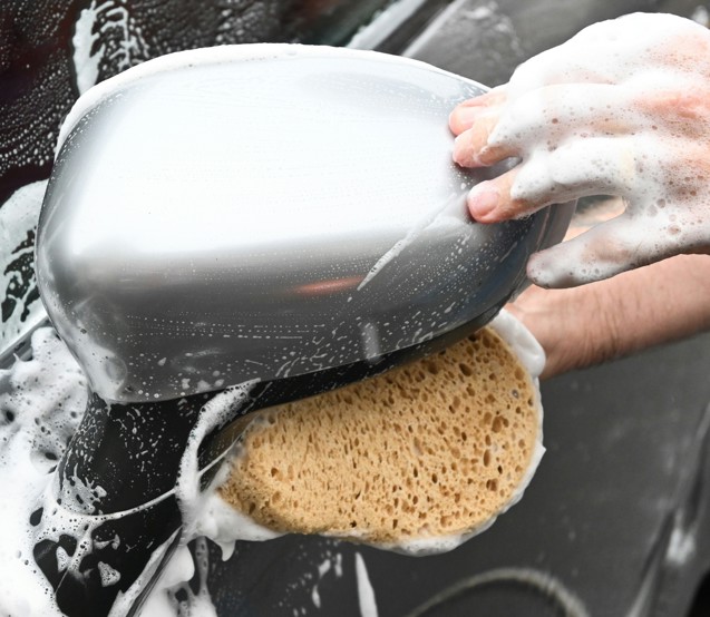 a person washing a car with a sponge