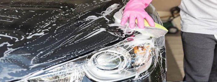 person washing car bonnet