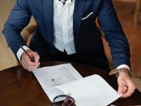 Man in a suit signing documents