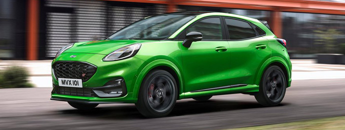 Front-side view of a Ford Puma ST in green driving on a road
