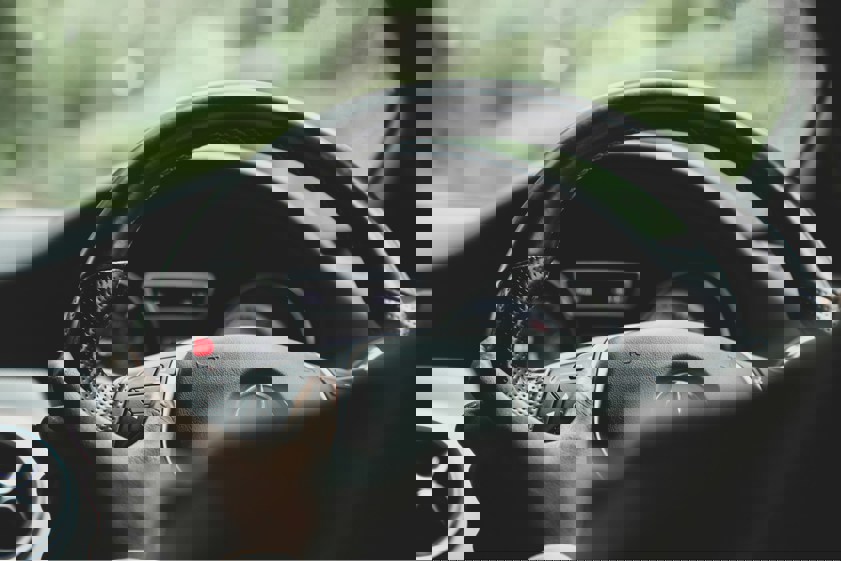 Person driving car with hands on the steering wheel
