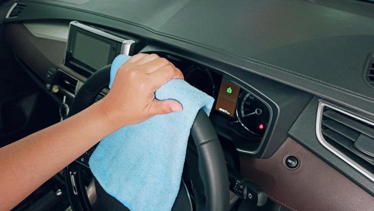Cleaning a car steering wheel with a blue cloth