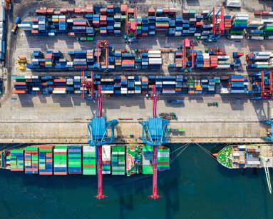 Merchant ship at a dock loading shipping containers