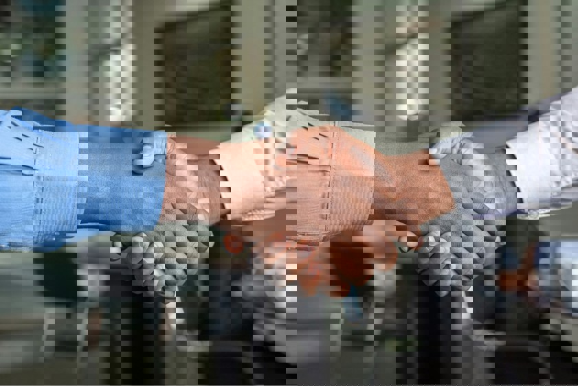 Two people shaking hands in business attire