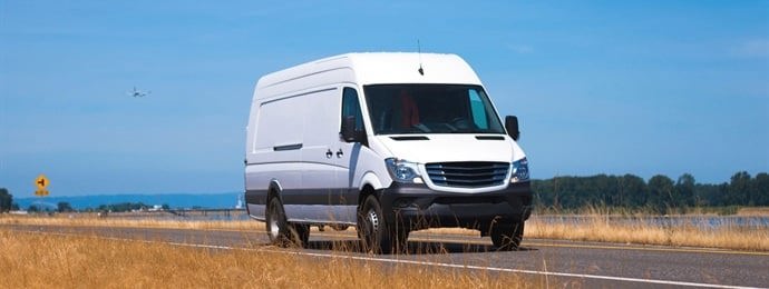 white van driving on the road