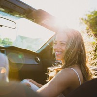 smiling woman sitting inside the vehicle at daytime
