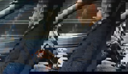 man working on laptop inside a car