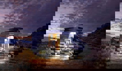 Converted van parked in desert at night