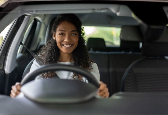 young woman behind the wheel of a supermini