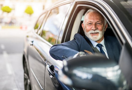 appy senior businessman sitting in his daily commuter and looking at camera.