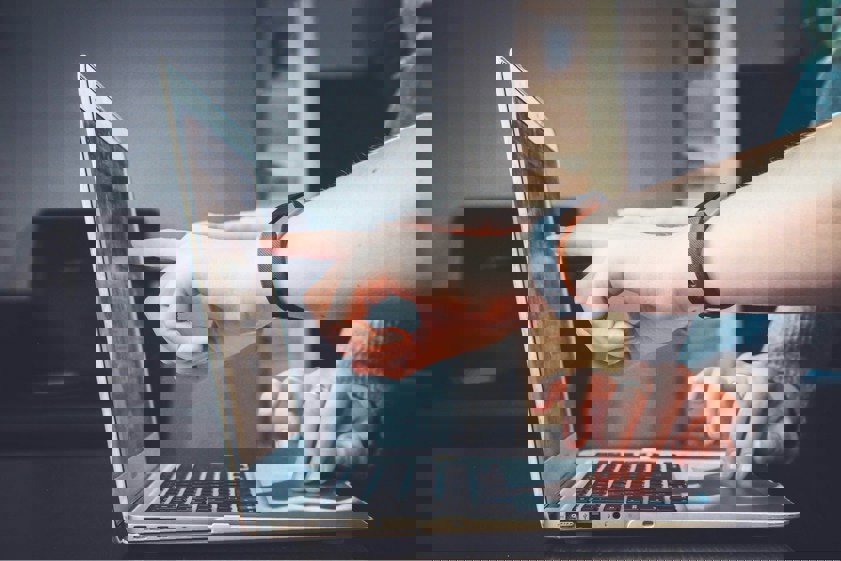 two people pointing at laptop screen