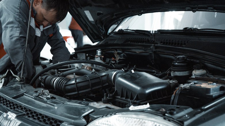 man servicing car
